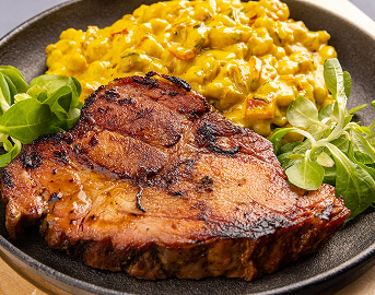 Grilled Pork Chop Served with Corn Medley at Assisted Living Facility Grilled Pork Chop Served with Corn Medley at Assisted Living Facility