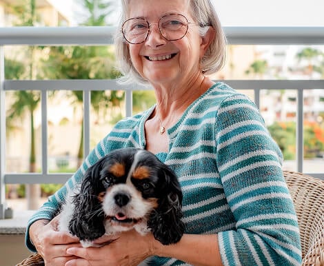 Elderly Woman Smiling with Pet Dog on Balcony at Assisted Living Facility Elderly Woman Smiling with Pet Dog on Balcony at Assisted Living Facility