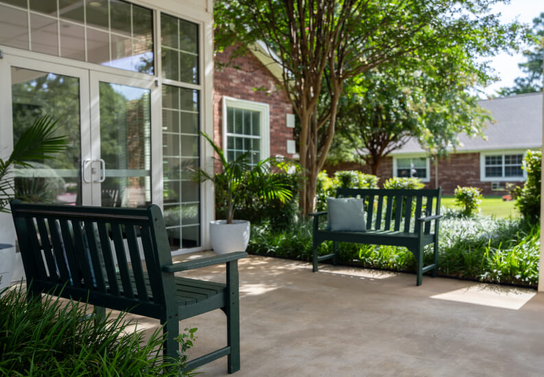 Outdoor Courtyard with Garden Benches and Landscaping at Assisted Living Facility Outdoor Courtyard with Garden Benches and Landscaping at Assisted Living Facility