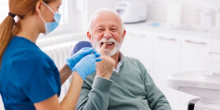 Elderly Man Receiving Dental Checkup from Female Nurse at Assisted Living Facility