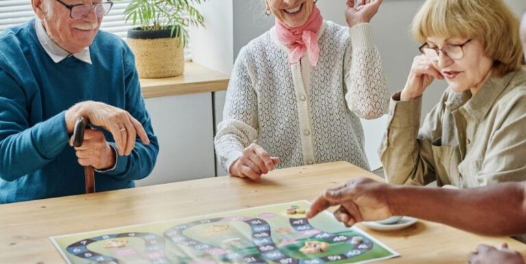 Elderly Friends Playing Board Game Together at Assisted Living Facility