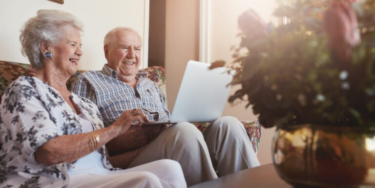 Elderly Couple Smiling while Using Laptop in Palestine at Memory Care Facility